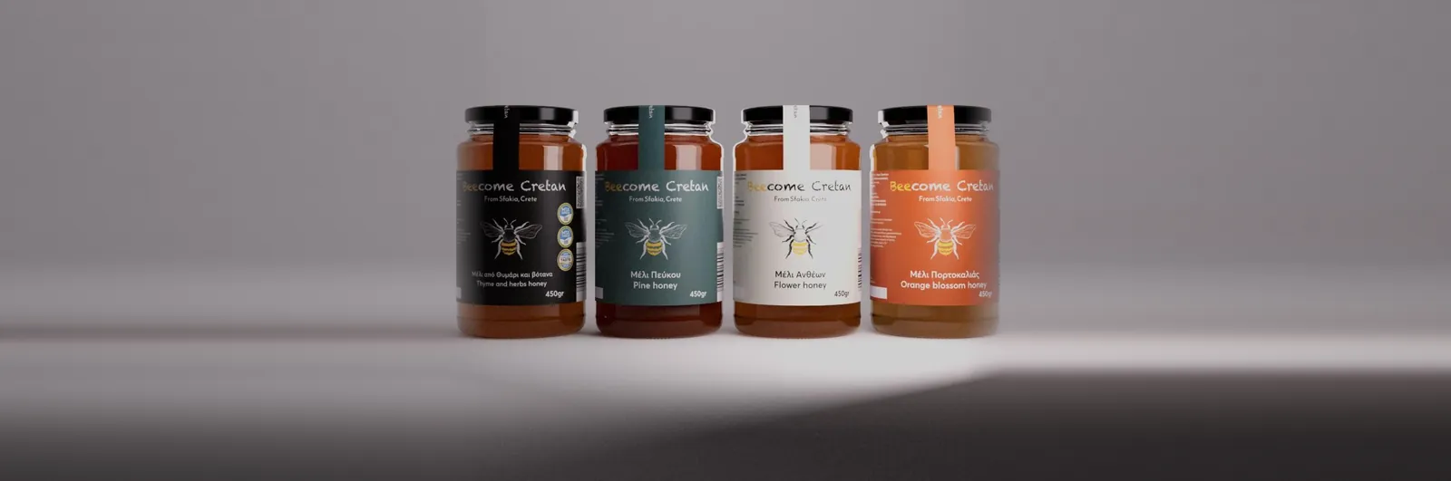 Τα τέσσερα μέλια Beecome Cretan σε βάζα 450gr: θυμαρίσιο με μαύρη ετικέτα, πεύκου με πράσινη, ανθέων με λευκή και πορτοκαλιάς με πορτοκαλί